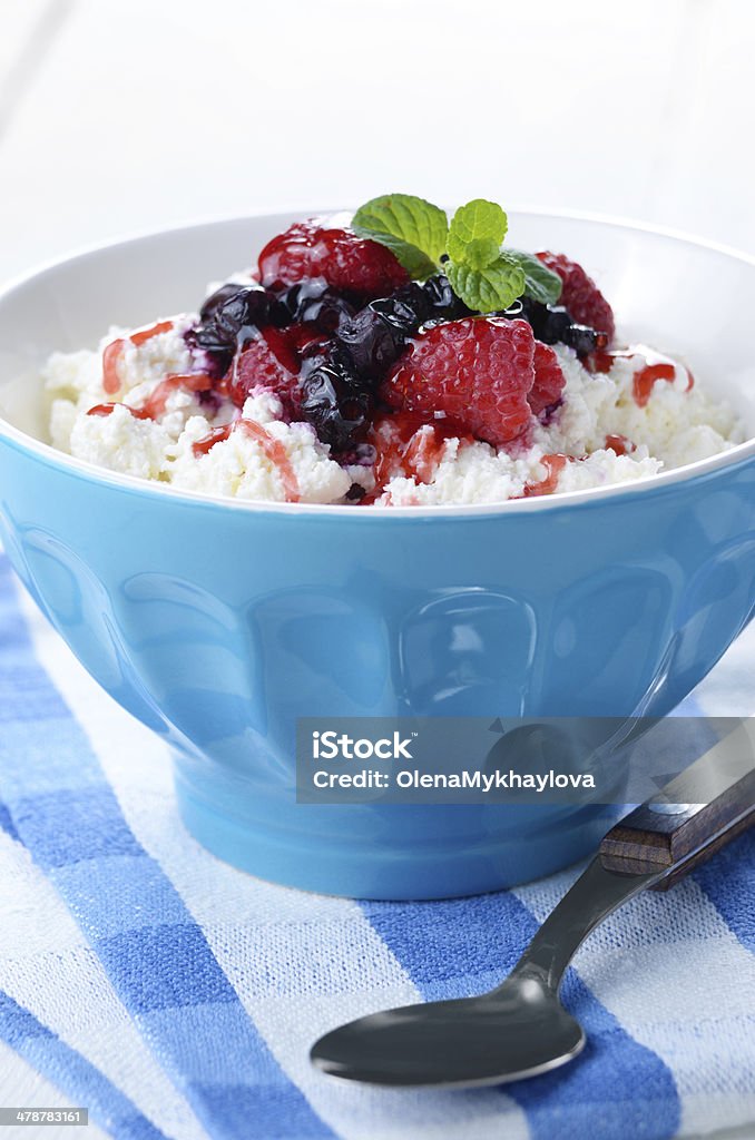 Cottage cheese with raspberries and blueberries Cottage cheese in blue bowl with raspberries blueberries and mint Berry Fruit Stock Photo