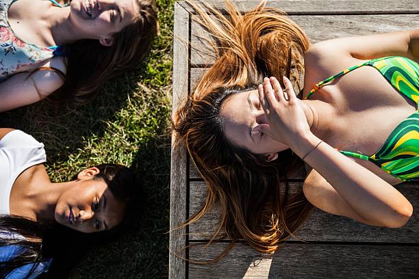 istock Teenager relaxing laying on a bench at park 478785932