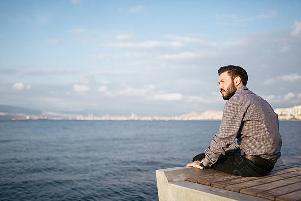 istock Young man sitting look at sea - Loneliness 478791530