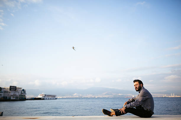 Young man sitting look at sea - Loneliness.