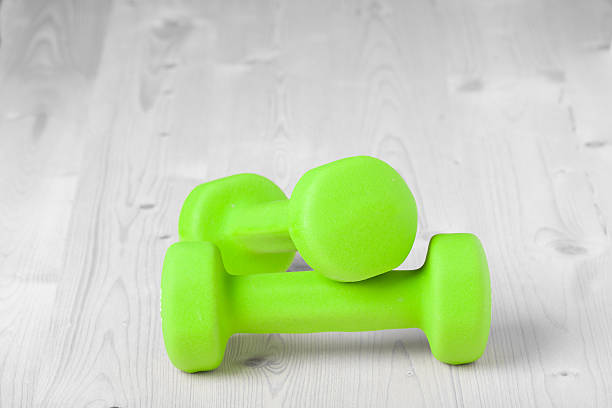 istock small green dumbbells on wooden surface 478800961