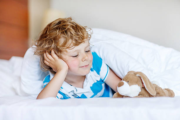istock Little blond child sleeping in his bed with toy. 478801274
