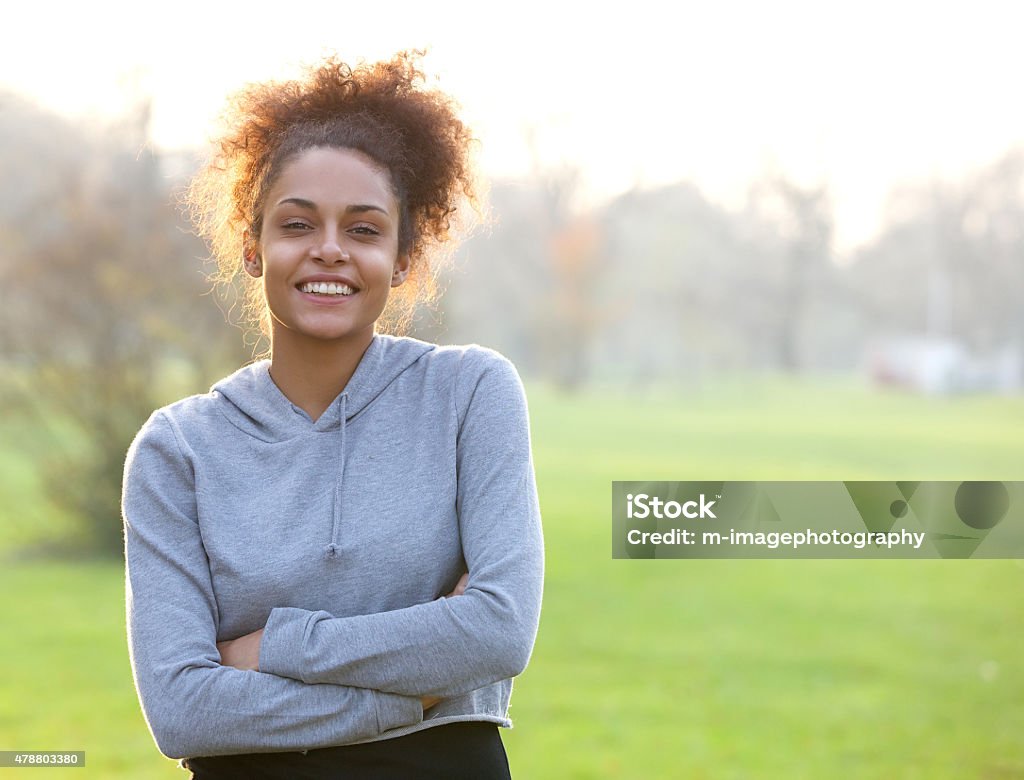Friendly young woman standing outside Portrait of a friendly young woman standing outside Sports Clothing Stock Photo