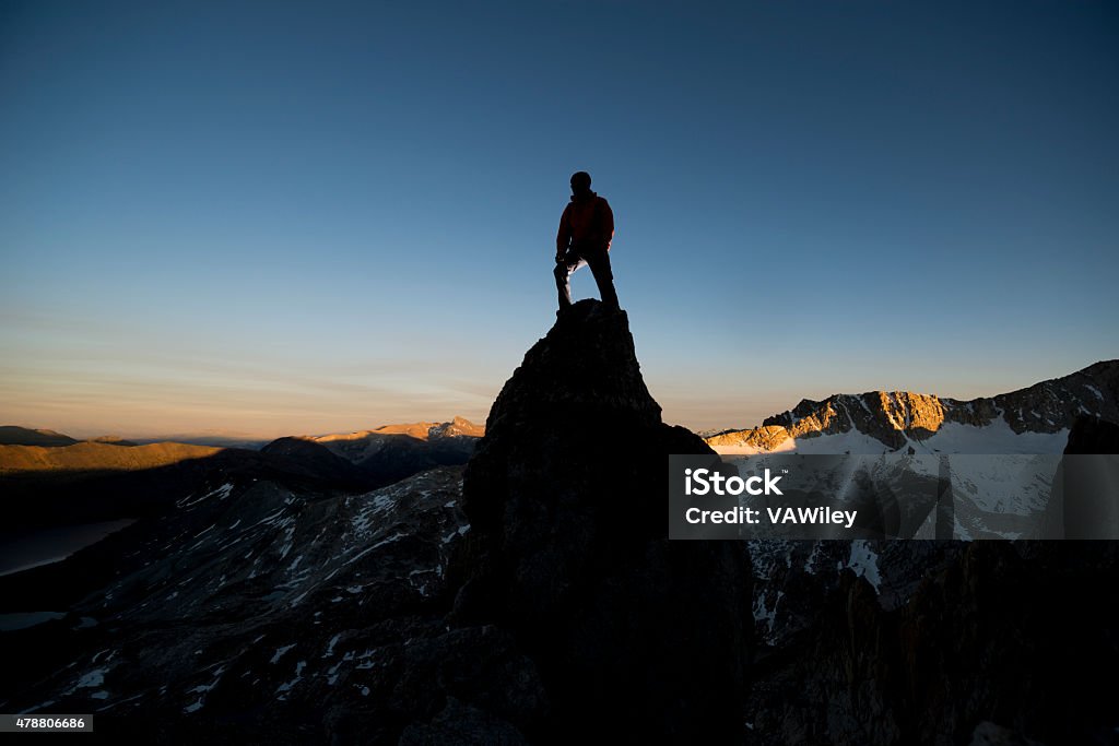 pinnicle fir mountain climber on the summit of a pinnacle at sunset  2015 Stock Photo