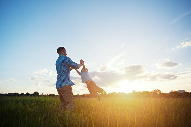 father spinning with his son stock photo