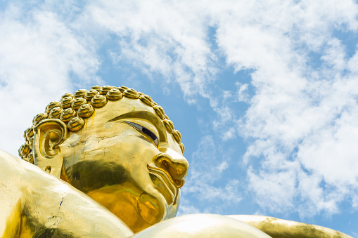 Golden Buddha statue of Big Buddha over blue sky. Chiang rai in thailand.