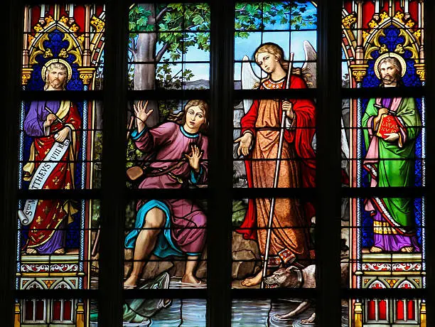 Stained Glass Window depicting Tobias and Saint Raphael with a fish in the river Tigris, in Den Bosch Cathedral, North Brabant. This window is created before 1895, no property release is required.