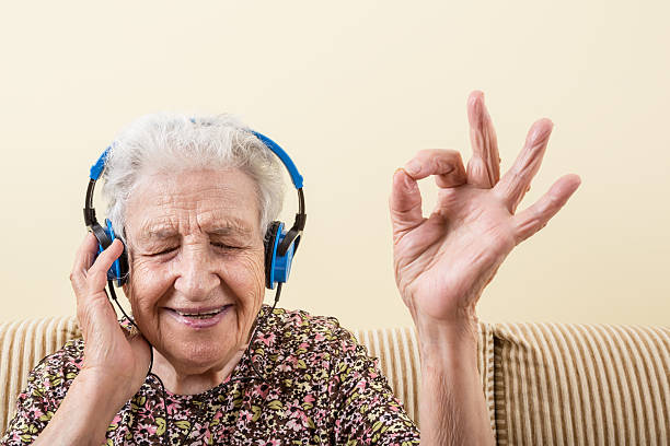 senior woman listening music stock photo