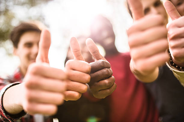 istock college student multiracial thumbs up at dusk 478815336