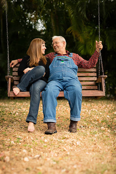 istock Grandpa and Granddaughter Sitting Together on Swing 478815708