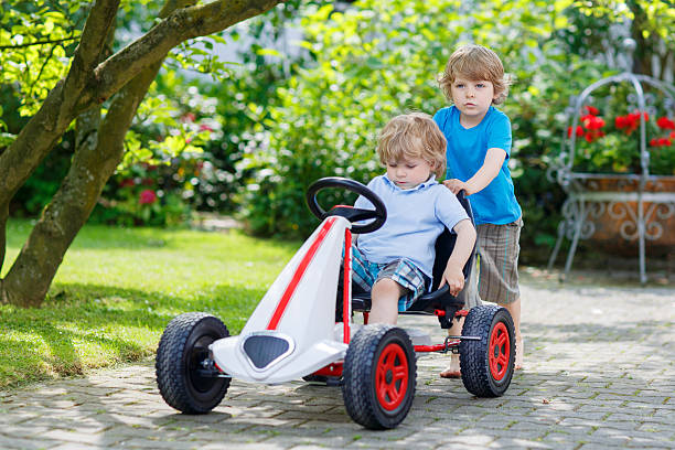 istock Two happy sibling boys having fun with toy car 478824248