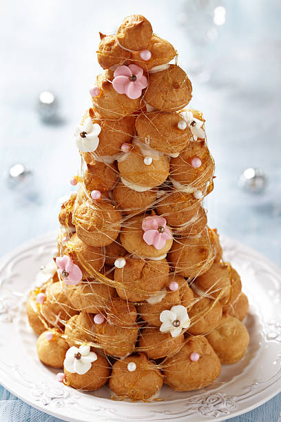 Croquembouche with Pink and White Frosting Roses Croquembouche with Pink and White Frosting Roses choux pastry photos stock pictures, royalty-free photos & images