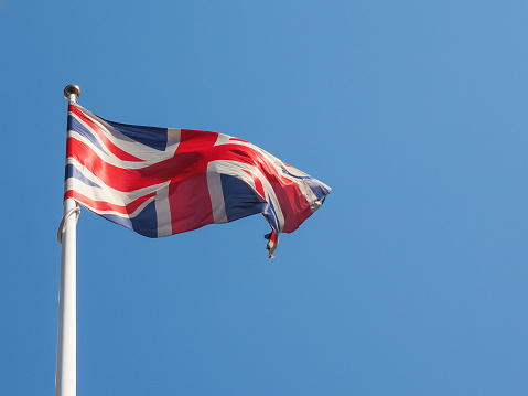 The national flag of United Kingdom, Europe floating in the wind over blue sky