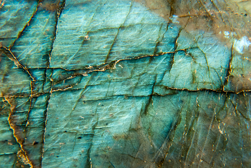 Macro of Labradorite polished specimen with blue and aqua iridescence. Labradorite is a semi-precious stone in the feldspar category.