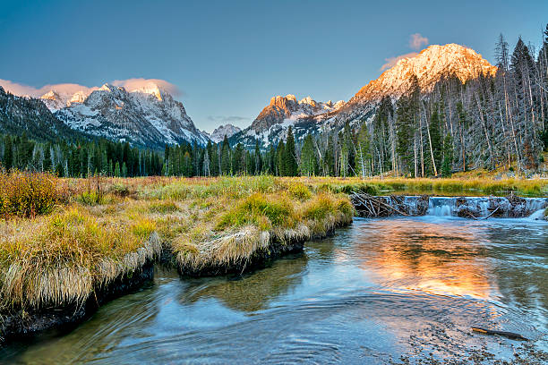 Beaver dam and snow capped mountains stock photo