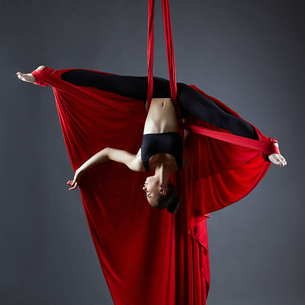 istock Graceful dancer on aerial silks posing upside down 478835246