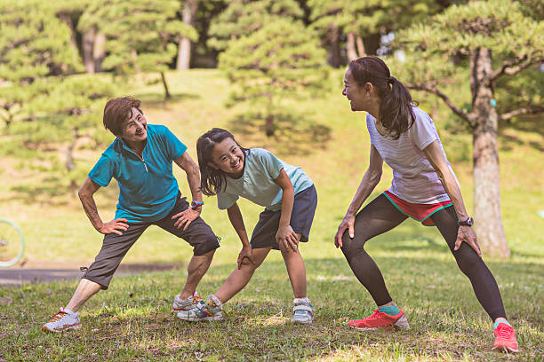 senior women with litlle chica de estiramiento en el parque yoyogi - family sport exercising jogging fotografías e imágenes de stock