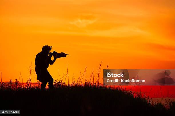 Silhouette Of Military Soldier Or Officer With Weapons At Sunset Stock Photo - Download Image Now