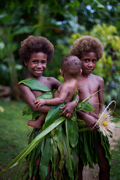 Melanesian children and baby in Luganville, Vanuatu Luganville, Vanuatu - February 16 2014: Melanesian children hold a baby in Lewaton cultural village. vanuatu stock pictures, royalty-free photos & images