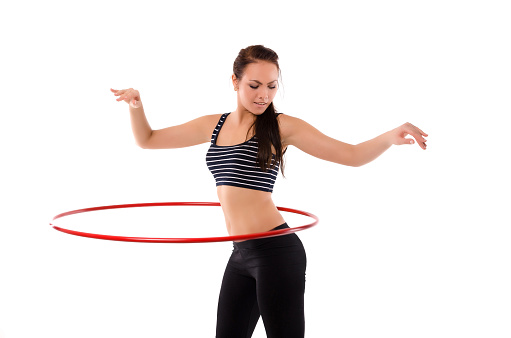 sportswoman doing hula hoop exercises isolated on white