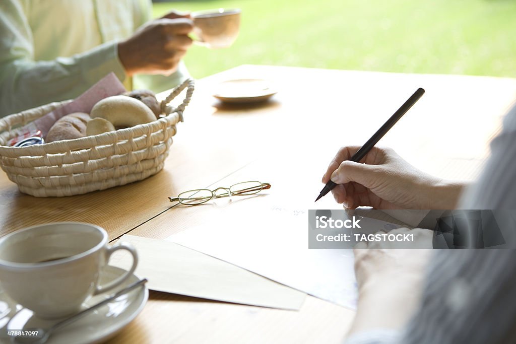 Hand of senior woman writing letter Writing - Activity Stock Photo