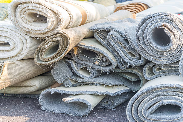 old carpet rolls old carpet rolls removed from hpme and ready to be throw out obsolescence stock pictures, royalty-free photos & images