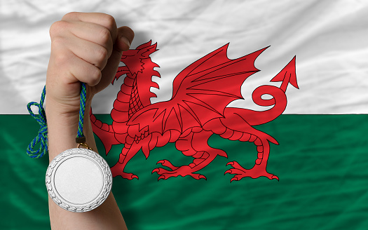 Holding silver medal for sport and national flag of wales