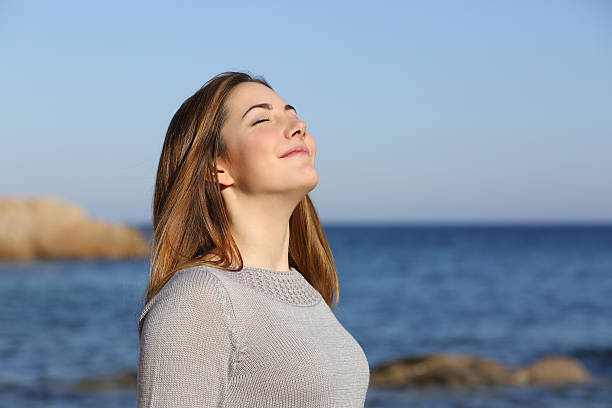 mujer feliz respirar profundo de aire fresco en la playa - beach sea zen like nature fotografías e imágenes de stock