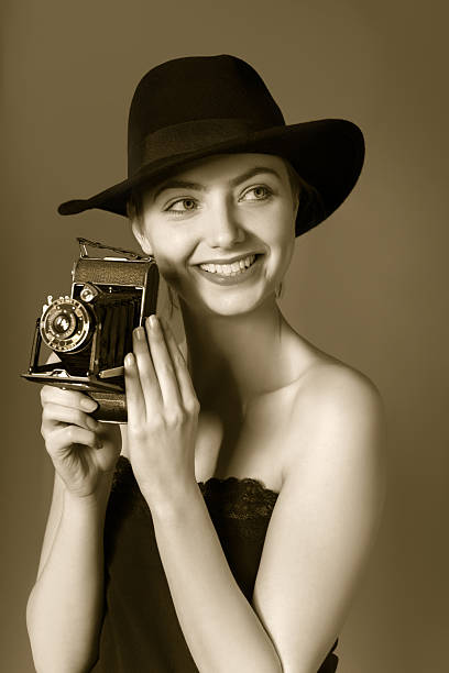 istock Attractive young lady in black hat with vintage portable camera 478849032