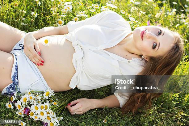 Pregnant Smiling Woman On Daisy Green Field Stock Photo - Download Image Now - 2015, Adult, Agricultural Field