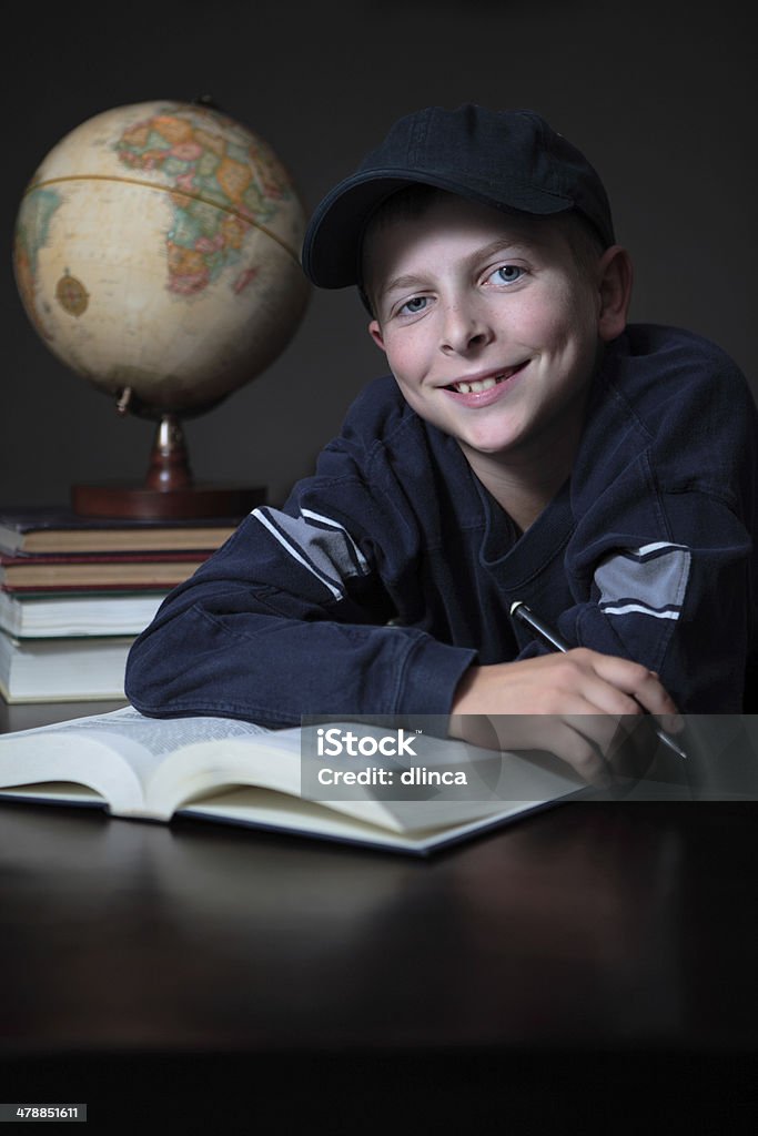 Menino pré-adolescente com tarefas escolares, sorrindo. - Foto de stock de 10-11 Anos royalty-free