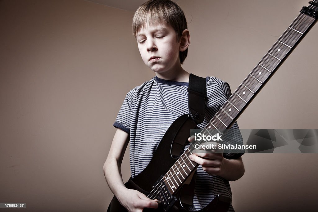 boy playing guitar boy playing guitar,   with a serious/concentrated expressin, eyes closed 10-11 Years Stock Photo