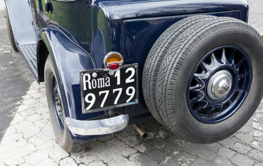 Rome, Italy - March 2, 2014: back tire and backside of a Lancia Augusta from 1934, in a gas station. The car is fully preserved in its original appearance.