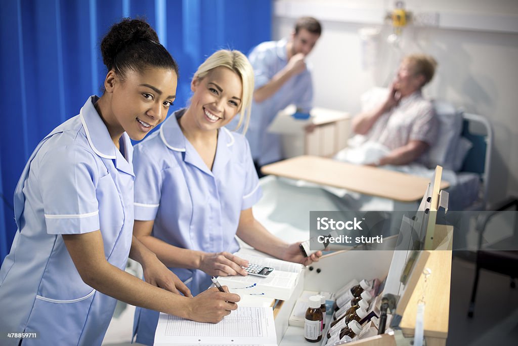 hospital dispensary nurses dispensing medicine on the ward Night Table Stock Photo