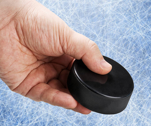 istock hand holding a hockey puck 478860839
