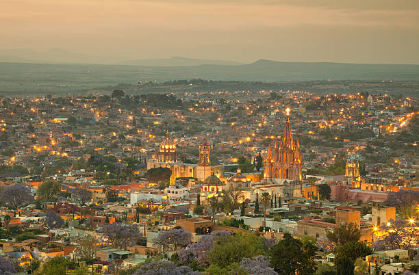 Skyline of San Miguel de Allende in Mexico After Sunset Illuminated skyline of San Miguel de Allende in Mexico after sunset, with a yellow filter effect. san miguel de cozumel stock pictures, royalty-free photos & images