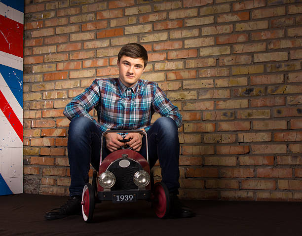 istock Smiling Man Sitting on Toy Automobile 478863700