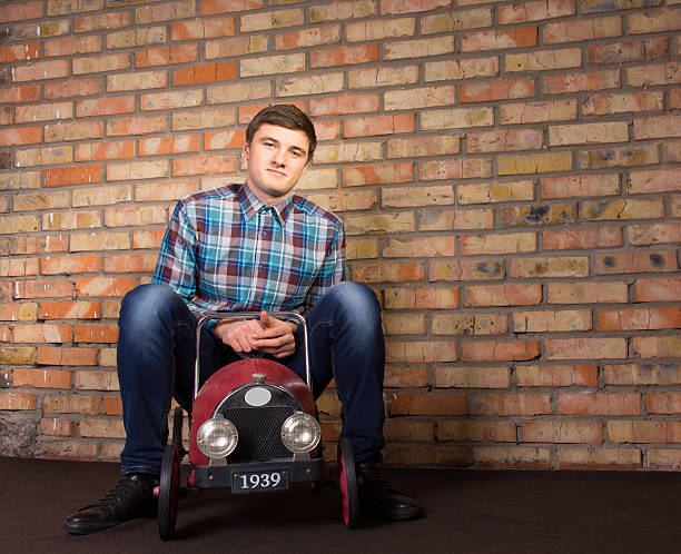 istock Young Man Sitting on Vintage Toy Vehicle 478863704