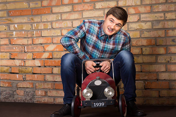 istock Young man having fun riding a toy truck 478863706