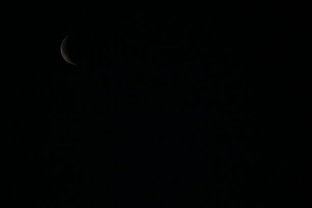 White moon shines in the dark clear sky.