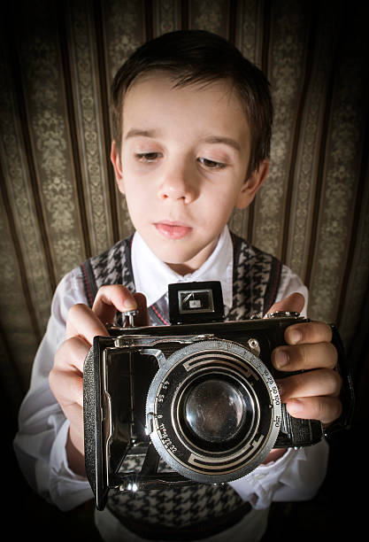 istock Child taking pictures with vintage camera 478874265