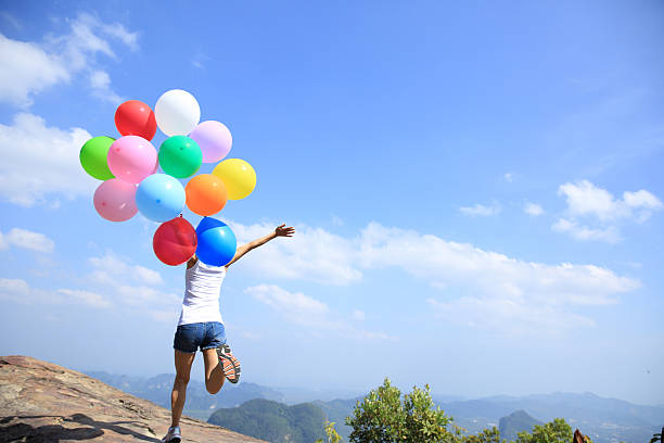 istock young asian woman running with colored balloons 478877620