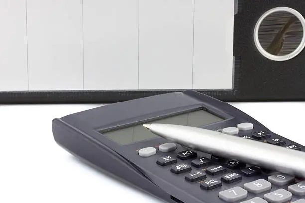 close up of a calculator with pen and dossier on the background