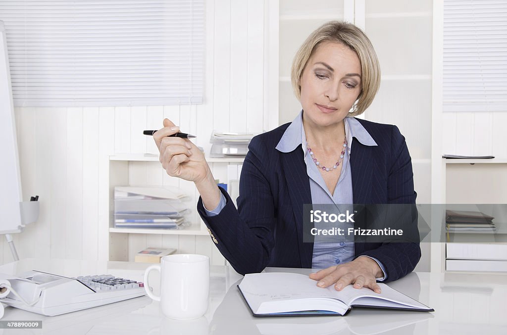 Senior business woman planning at desk. Older businesswoman sitting in her office. 40-49 Years Stock Photo
