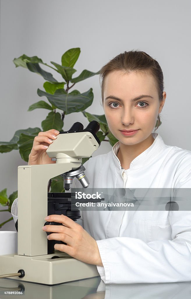 Young histopathologist or student works with microscope Young histopathologist or student works with transmissioon light microscope 2015 Stock Photo