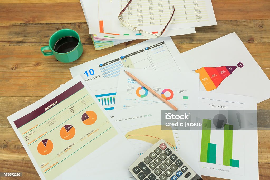 Business concept of a pencil, charts, eyeglasses, calculator, coffee cup Blue Stock Photo
