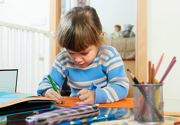 istock serious child drawing on paper in home 478904913