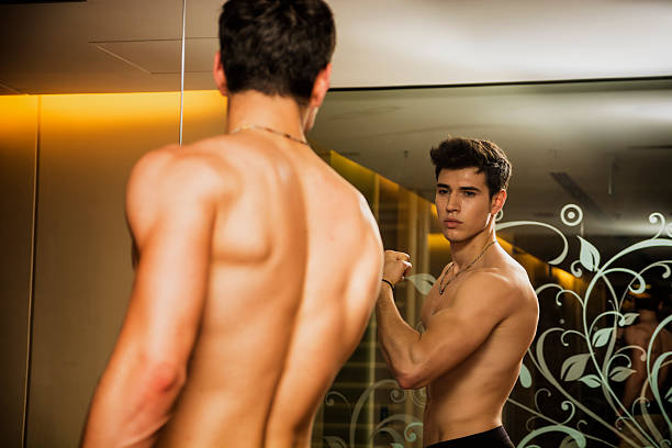 istock Young Man Admiring Bicep Muscles in Mirror 478905868