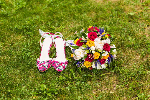 Pink wedding shoes and bridal bouquet with  different flowers