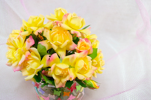 Bouquet of yellow roses on a white silken sheet